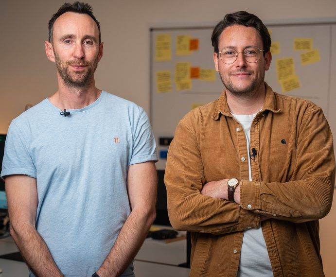 Ed and Calum — co-founders of Humble&Brag — in front of a wall of sticky notes